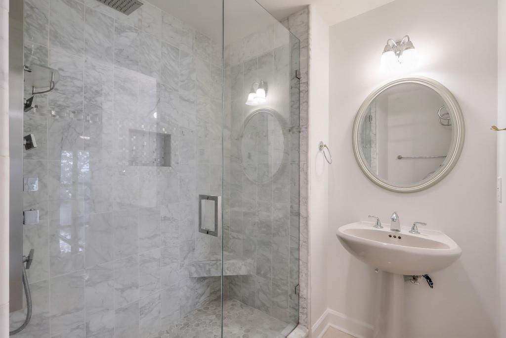 3475 Oak Valley Road Northeast, Unit 530 Atlanta, GA 30326 - Photo 23 of 37 a bathroom with a sink a mirror and shower