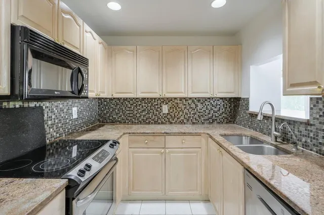 a kitchen with granite countertop a sink and a white stove