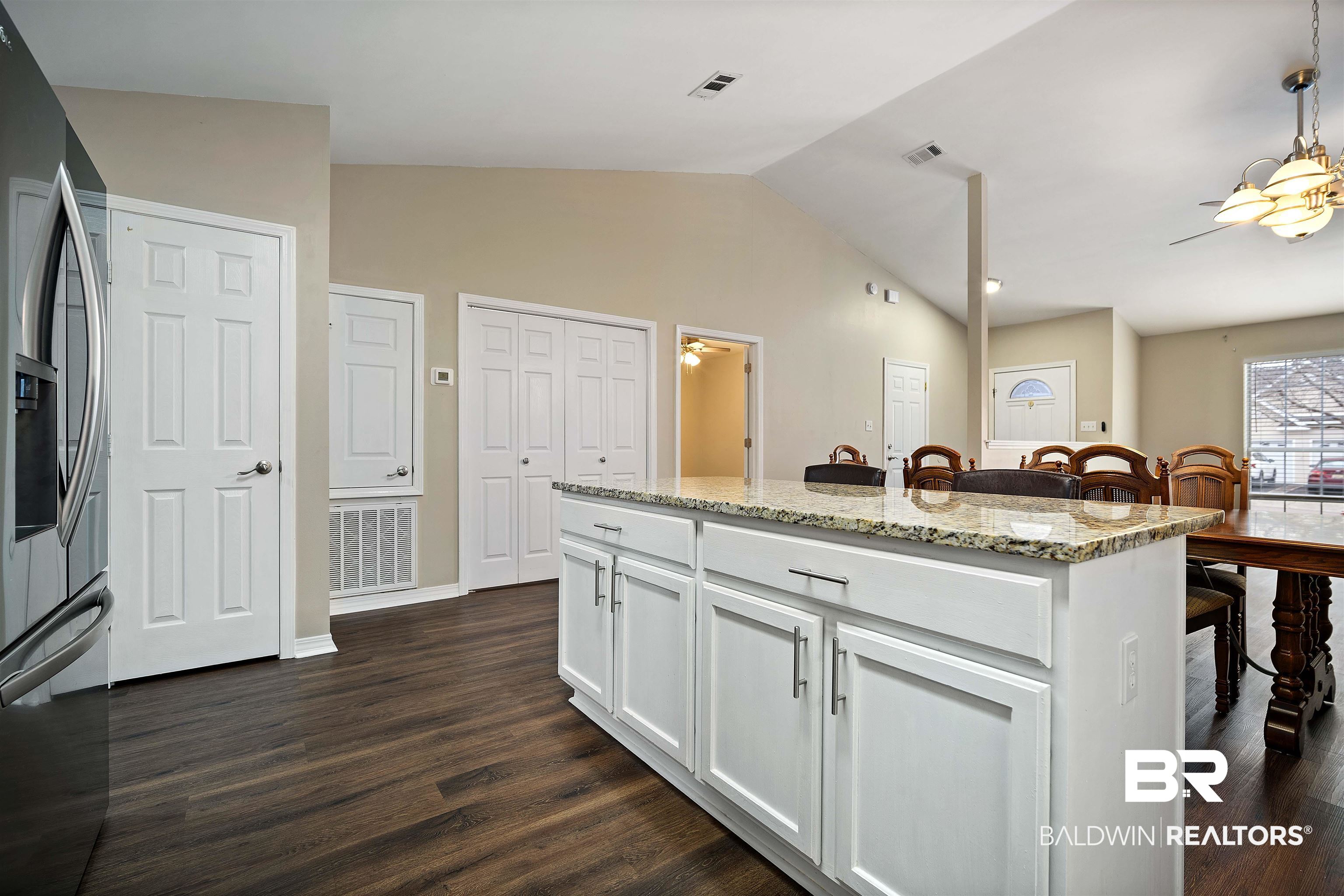 628 Spring Lake Court Mobile, AL 36695 - Photo 8 of 25 Kitchen featuring stainless steel fridge, dark hardwood / wood-style floors, light stone countertops, white cabinets, and a kitchen island