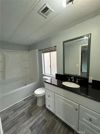 a bathroom with a double vanity sink toilet a mirror and bathtub
