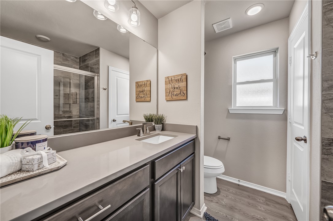 1220 High Street Navasota, TX 77868 - Photo 11 of 17 a bath room with a sink a toilet and a mirror