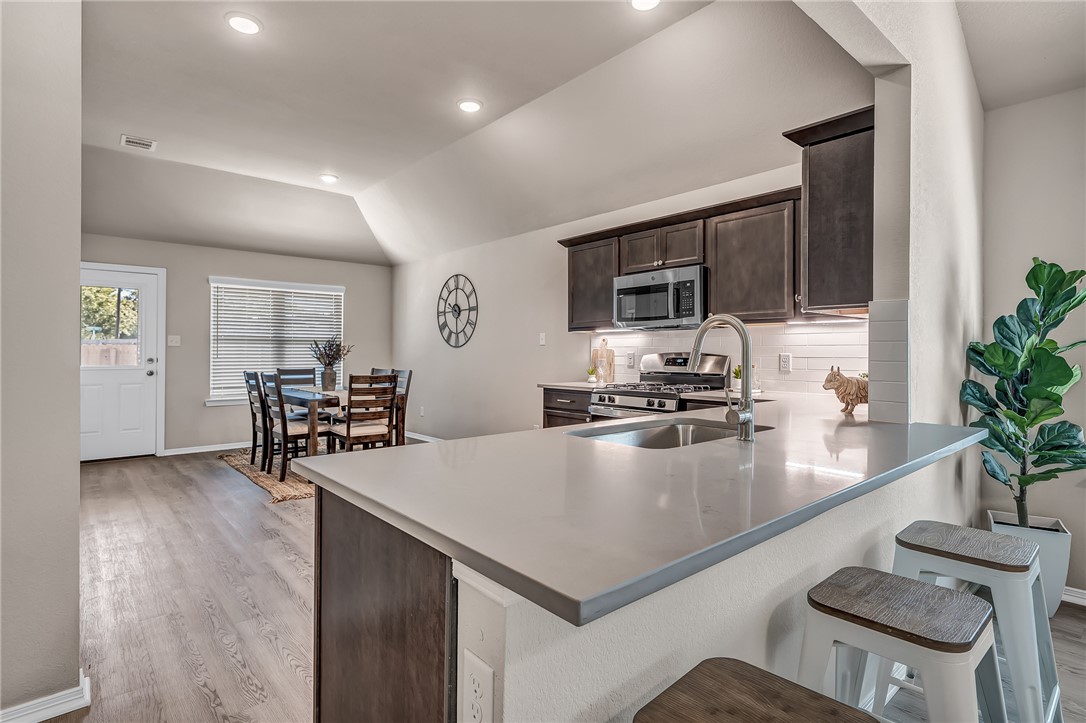 1220 High Street Navasota, TX 77868 - Photo 4 of 17 a kitchen with a table chairs refrigerator and microwave