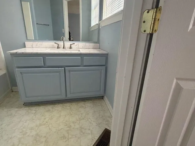 a bathroom with a granite countertop sink and a mirror