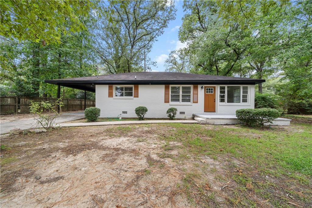 a view of a house with backyard and chairs