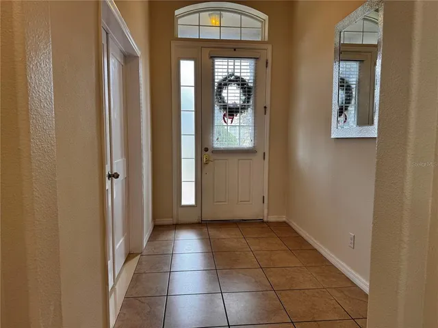 a view of a hallway with wooden floor and a living room