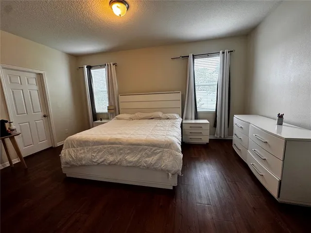 a bedroom with a bed wooden floor and a chair