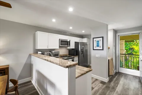 a kitchen with stainless steel appliances granite countertop a sink a stove a microwave oven and a refrigerator