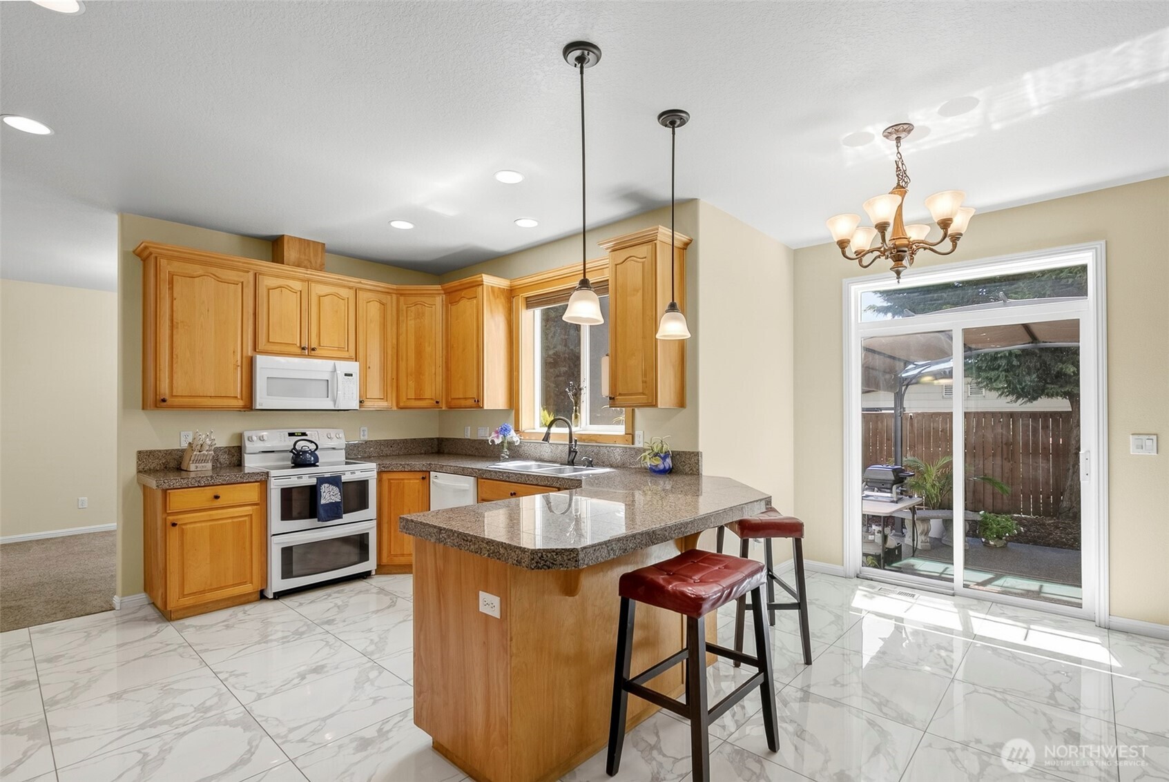 16715 Northeast 5th Street Vancouver, WA 98684 - Photo 6 of 34 a kitchen with kitchen island a large counter top space appliances and a center island