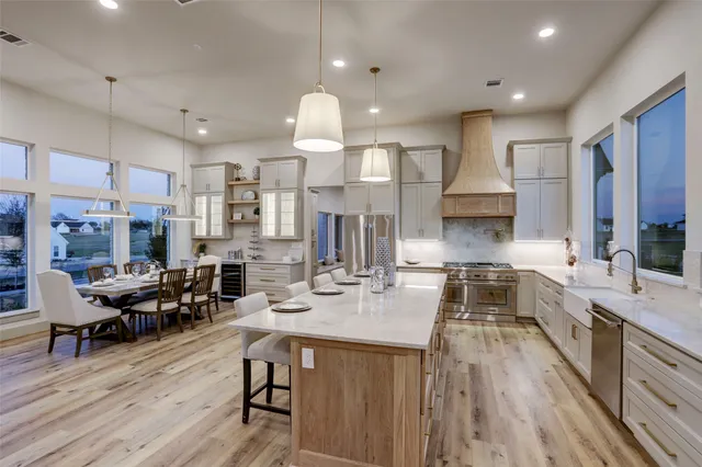 a large kitchen with lots of counter space dining table and stainless steel appliances