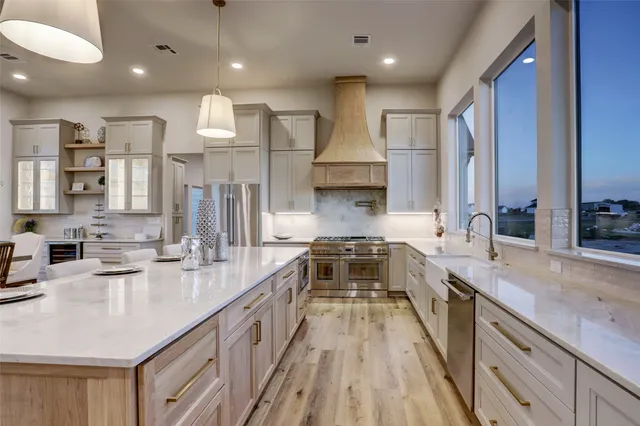 a kitchen with stainless steel appliances granite countertop a sink stove and cabinets