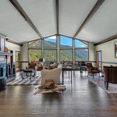 a living room with fireplace furniture and a large window