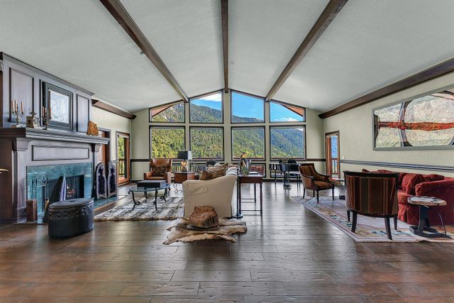 a living room with fireplace furniture and a large window