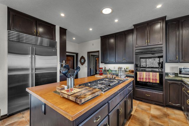 a kitchen with kitchen island granite countertop a sink stainless steel appliances and cabinets