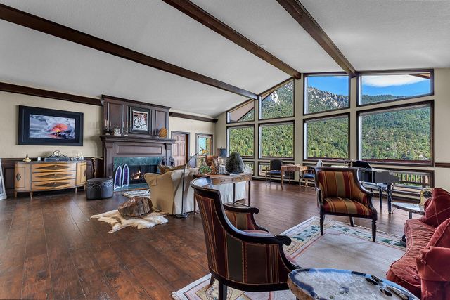 a living room with furniture a fireplace and large windows