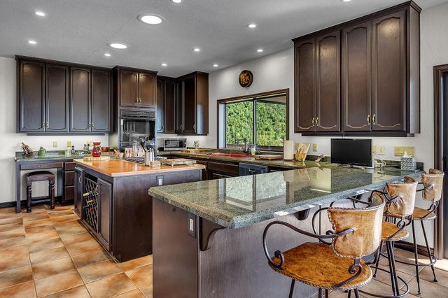 a kitchen with stainless steel appliances granite countertop a stove top oven a sink dishwasher and cabinets with wooden floor