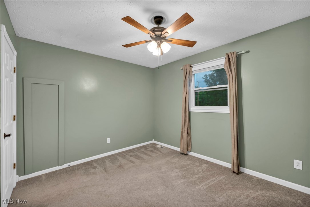 47655 Cooper Foster Park Road Amherst, OH 44001 - Photo 14 of 49 Unfurnished room featuring carpet flooring, ceiling fan, and a textured ceiling