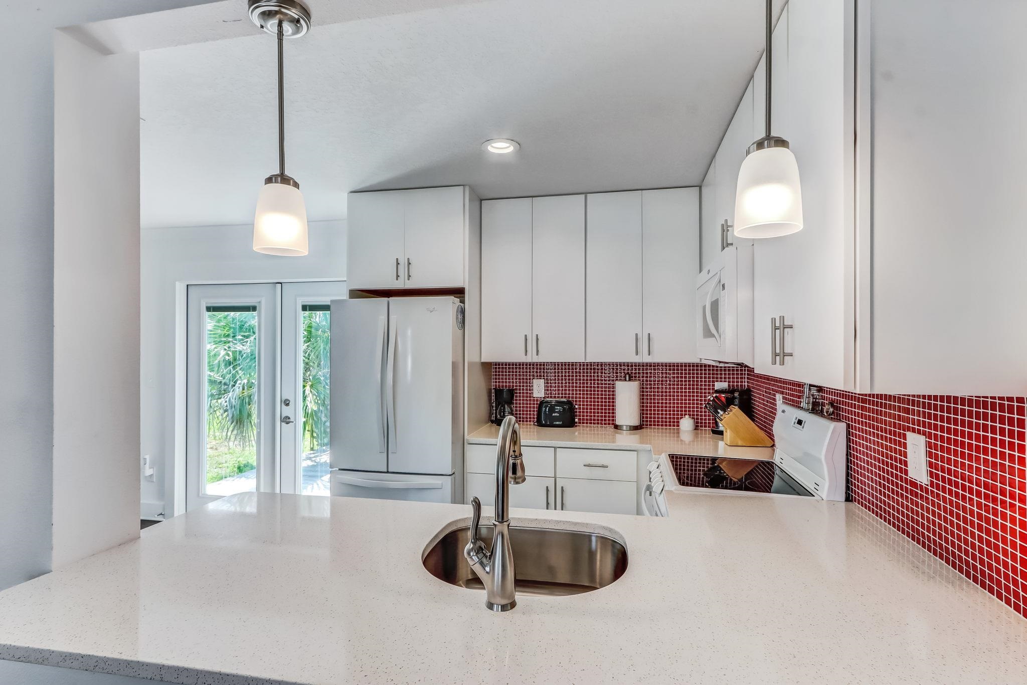 28 Atlantic Avenue St. Augustine, FL 32084 - Photo 9 of 23 a kitchen with kitchen island a sink and a chandelier