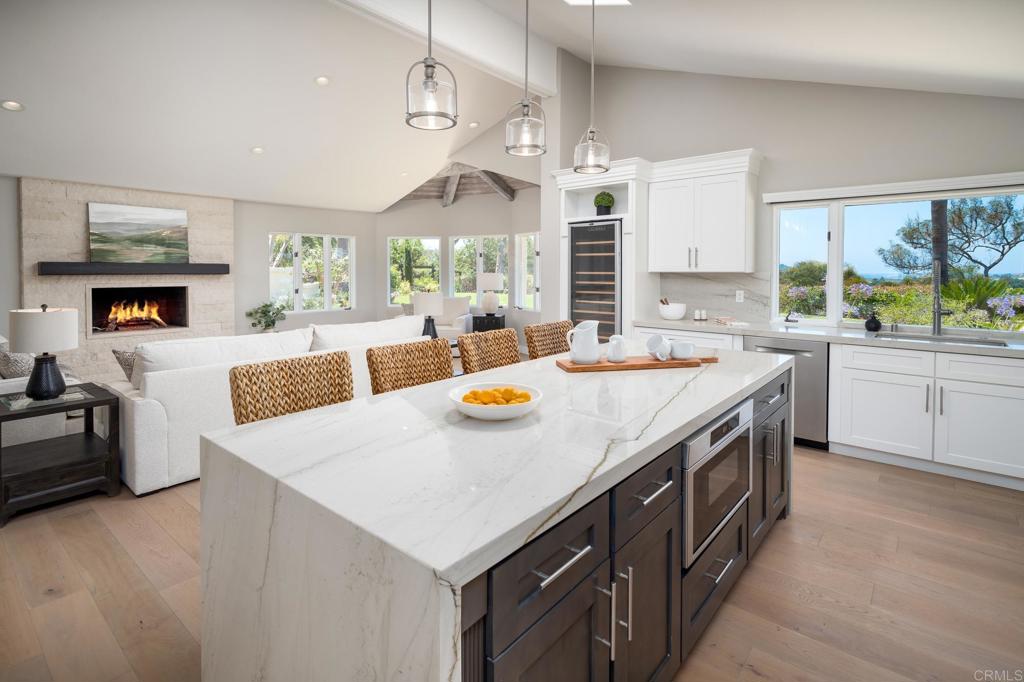 5002 El Acebo Rancho Santa Fe, CA 92067 - Photo 12 of 55 a kitchen with stainless steel appliances a table chairs and a refrigerator