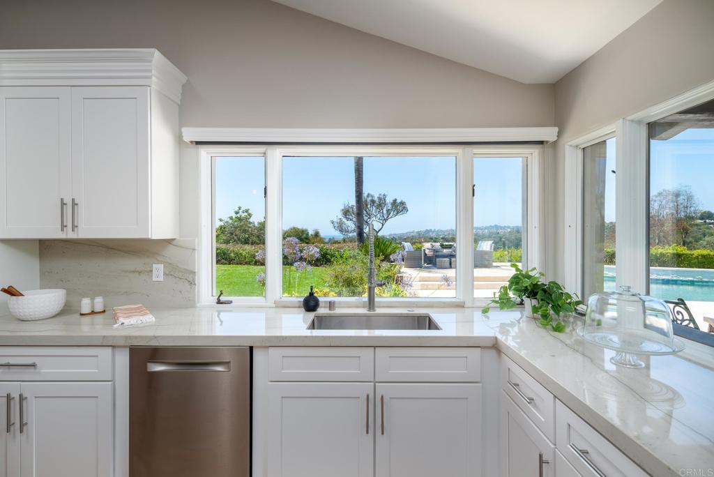 5002 El Acebo Rancho Santa Fe, CA 92067 - Photo 13 of 55 a kitchen with kitchen island a sink a large window cabinets and a counter space