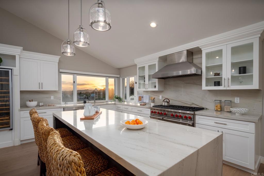 5002 El Acebo Rancho Santa Fe, CA 92067 - Photo 10 of 55 a kitchen with stainless steel appliances a table chairs in it and wooden floors