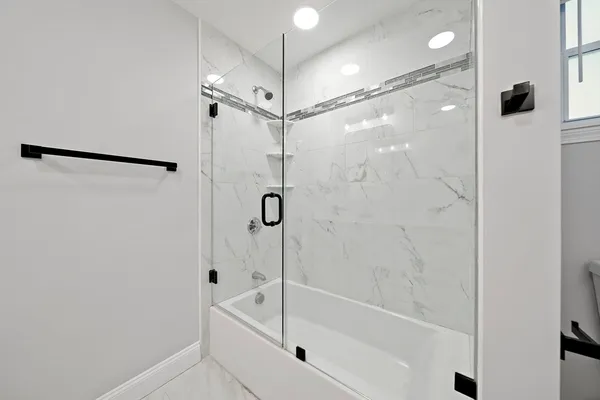 a bathroom with a shower and a bath tub