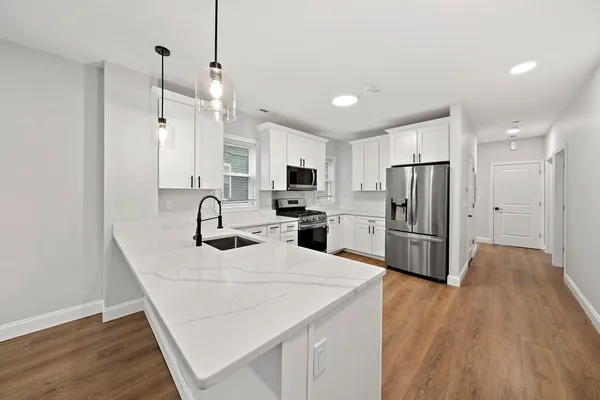 a kitchen with refrigerator cabinets and wooden floor