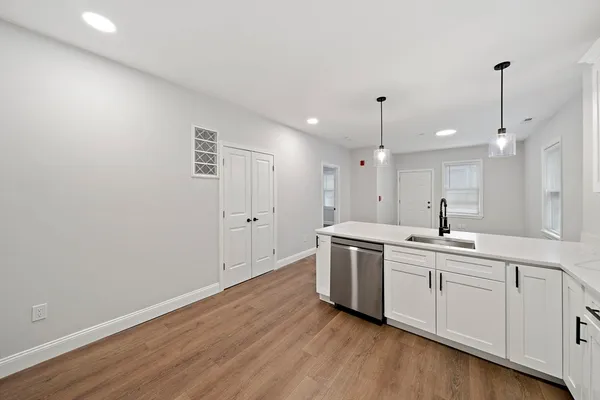 a kitchen with a sink cabinets and wooden floor