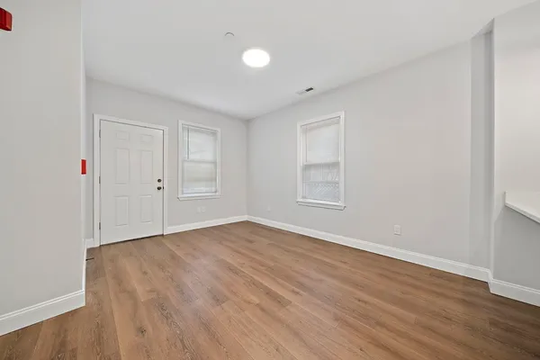 a view of an empty room with wooden floor