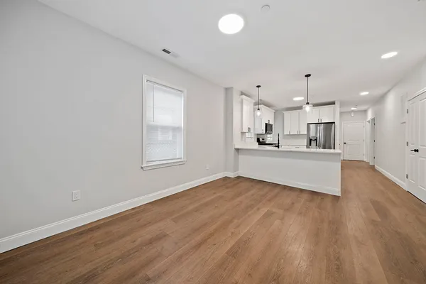 a view of a kitchen with wooden floor and a window
