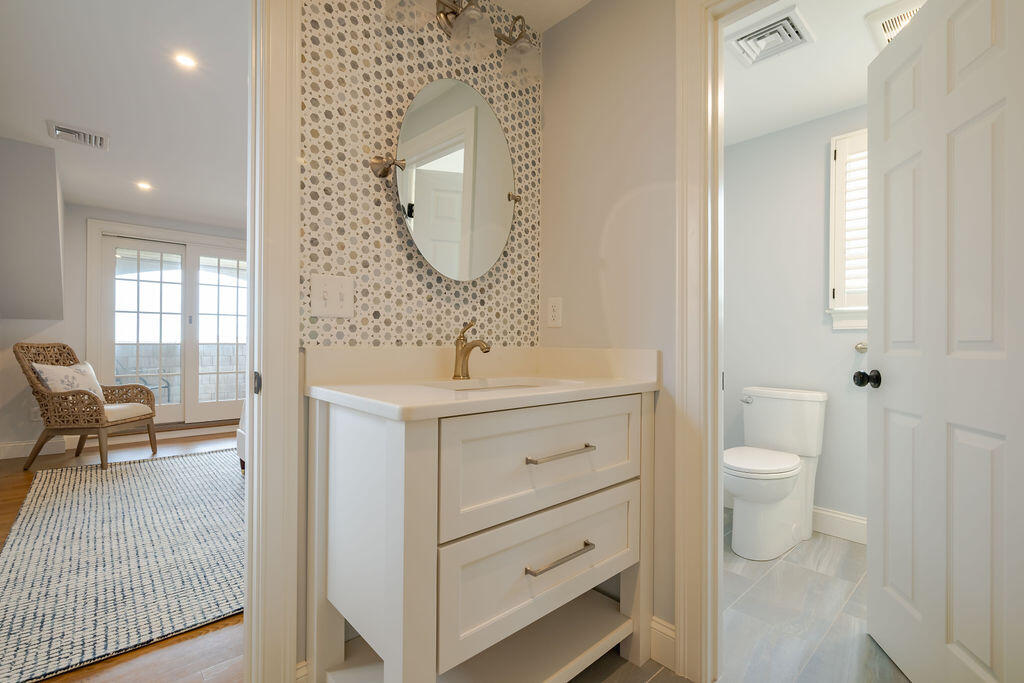 39 Bay Shore Road Hyannis, MA 02601 - Photo 32 of 63 a bathroom with a toilet a sink a mirror and a window
