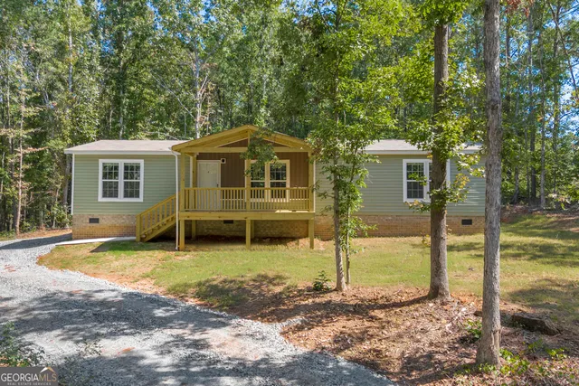a view of a house with backyard and trees