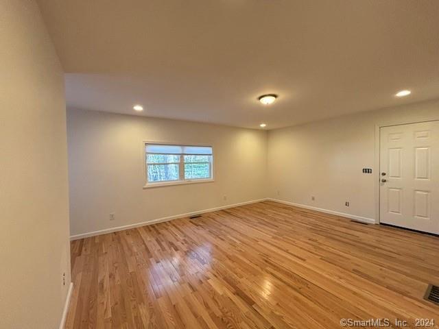 86 Pocahontas Road Redding, CT 06896 - Photo 4 of 23 an empty room with wooden floor and windows