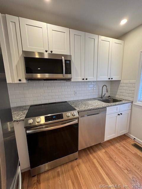 86 Pocahontas Road Redding, CT 06896 - Photo 6 of 23 a kitchen with granite countertop white cabinets and black appliances