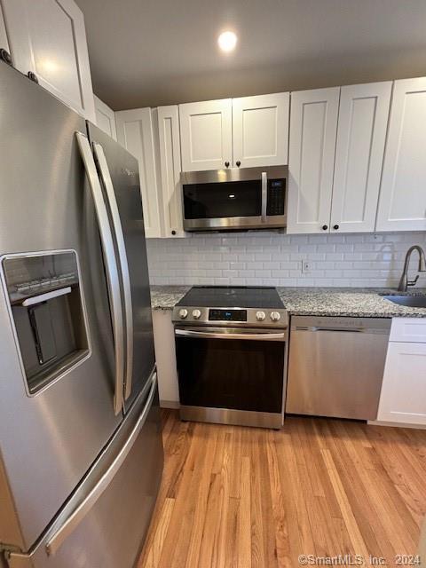 86 Pocahontas Road Redding, CT 06896 - Photo 7 of 23 a kitchen with stainless steel appliances granite countertop a refrigerator a sink a stove and white cabinets
