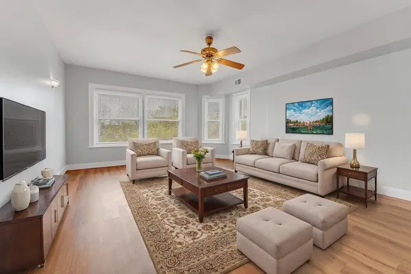 a living room with furniture a flat screen tv and a window