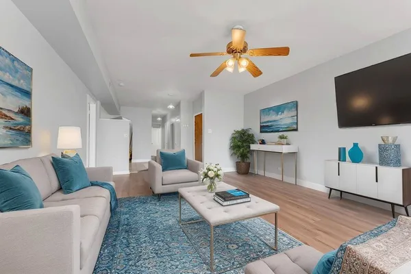 a living room with furniture a flat screen tv and a fireplace