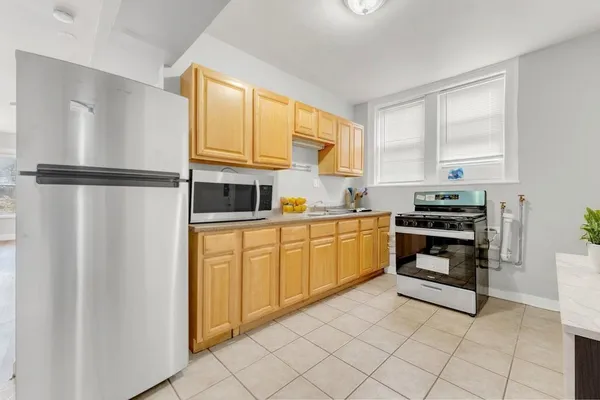 a kitchen with a refrigerator a stove a sink and a window