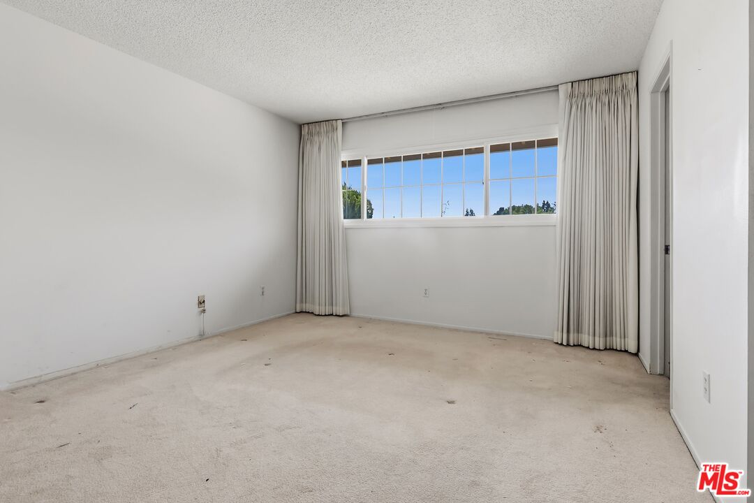 19131 Tulsa Street Porter Ranch, CA 91326 - Photo 23 of 43 an empty room with closet and wooden door
