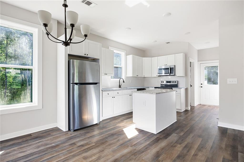205 Pinecrest Road Cedartown, GA 30125 - Photo 11 of 27 a kitchen with white cabinets and stainless steel appliances