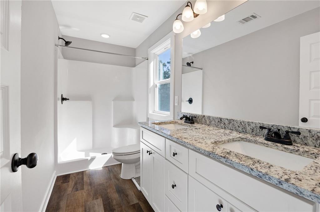 205 Pinecrest Road Cedartown, GA 30125 - Photo 20 of 27 a bathroom with a granite countertop sink a toilet a mirror and shower