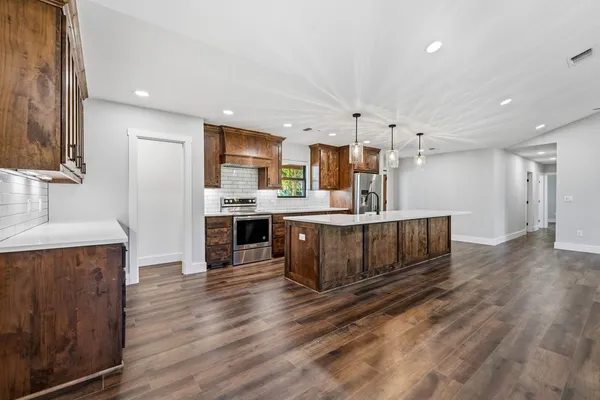 a kitchen with stainless steel appliances kitchen island wooden cabinets and granite counter tops