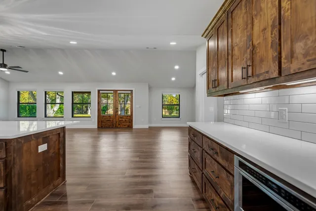 a view of an empty room with window and wooden floor