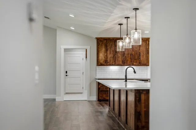 a kitchen with stainless steel appliances granite countertop a sink and a refrigerator