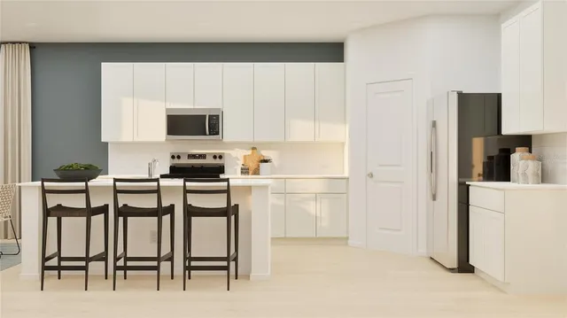 a kitchen with white cabinets and stainless steel appliances