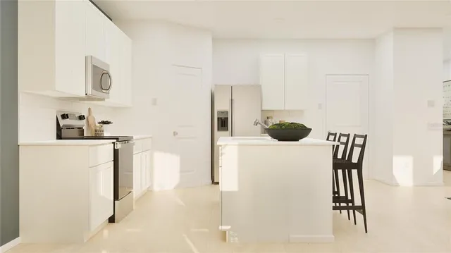 a kitchen with stainless steel appliances a refrigerator sink and white cabinets