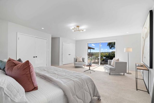 a bedroom with a bed a couch and a flat screen tv