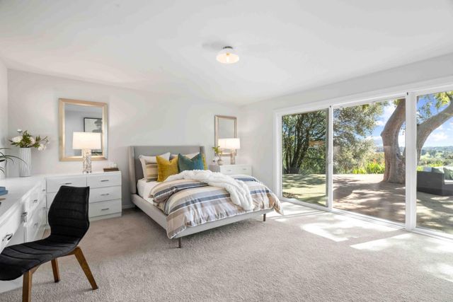 a spacious bedroom with a bed a table and chair