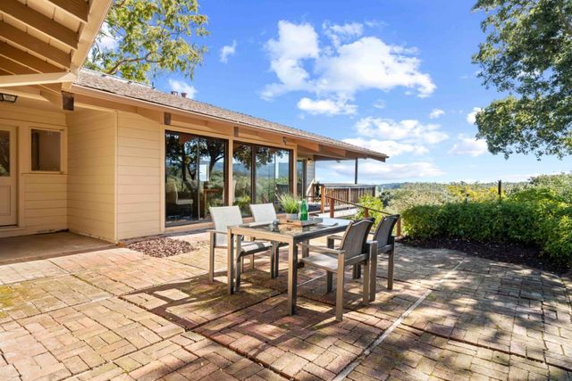 a view of a patio with table and chairs with wooden floor and fence
