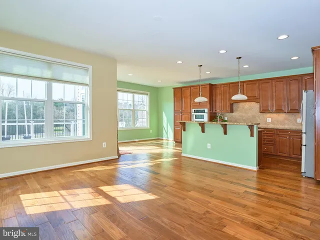 a view of a kitchen with wooden floor and a window