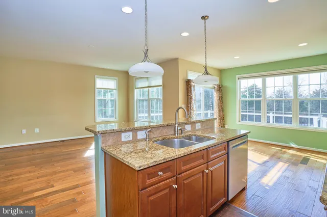 a kitchen that has a sink a stove and a wooden floor